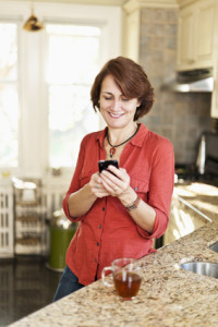 Woman using cell phone at home